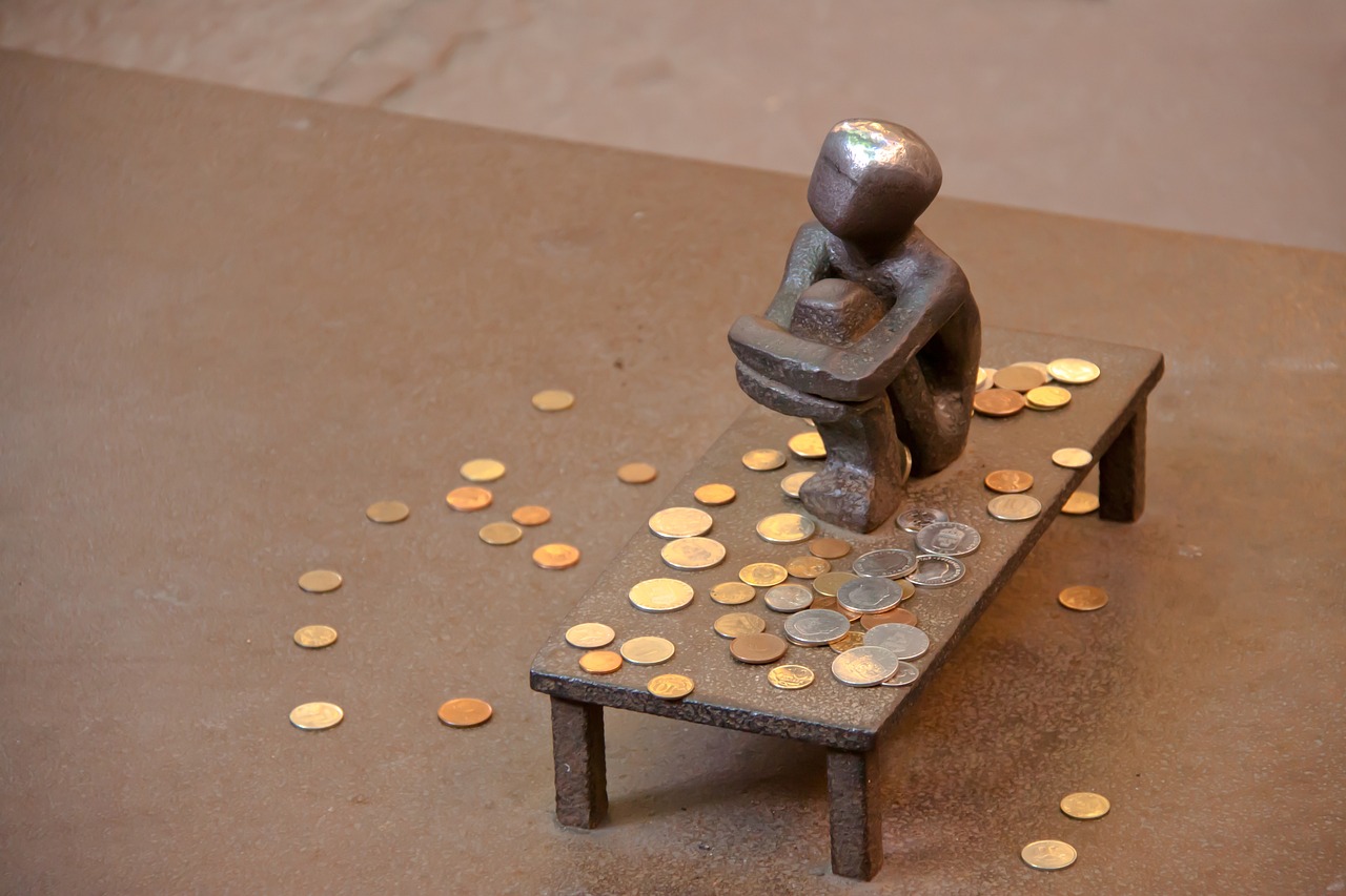 Miniatur Bronze-Figur auf Tisch umgeben von Kleingeld